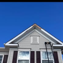 A house with a ladder on the roof, showcasing windows & shutters during installation in Delaware.